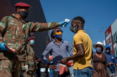 South African National Defense Forces check people's temperature near the Pan Africa taxi rank in Johannesburg's Alexandra…