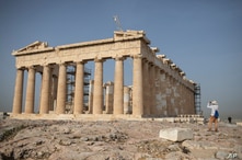 A man takes a picture next the ancient Parthenon temple at the Acropolis hill of Athens, on Monday, May 18, 2020. Greece…