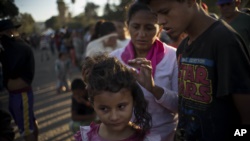 Miles de niños esperan junto a sus padres en los campos improvisados en México para atender a los migrantes llegados desde Centroamérica.