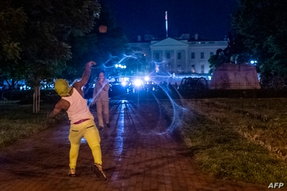 TOPSHOT - Protesters face off with police outside the White House in Washington, DC, early on May 30, 2020, during a…