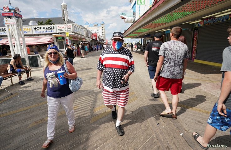 With the coronavirus disease (COVID-19) restrictions eased, a man dressed in stars and stripes for Memorial Day weekend walks…