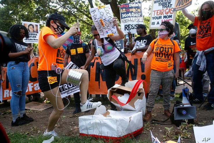 Protesters destroy a mock birthday cake for President Donald Trump on Trump's birthday, Sunday, June 14, 2020, in Lafayette…