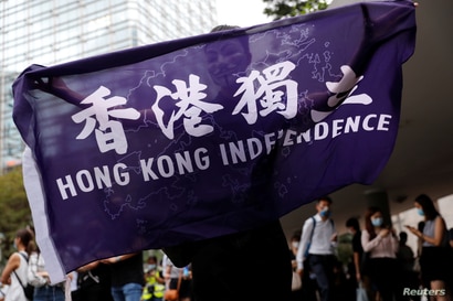 A pro-democracy demonstrator holds a flag supporting Hong Kong Independence during a protest to mark the first anniversary of a…