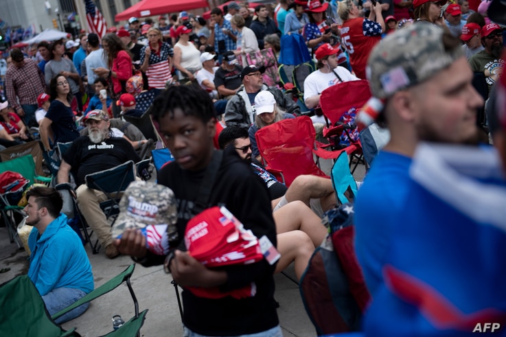 A vender sells memorabilia as people wait to attend a rally with US President Donald Trump this evening at the BOK Center on…