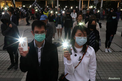 Una marcha de manifestantes en Hong Kong recordó a los muertos y heridos en las protestas durante el año que se va.