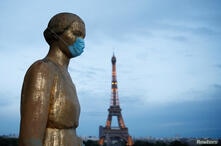 La estatua de oro en la plaza Trocadero, cerca de la torre Eiffel, usa una máscara protectora durante el brote de la enfermedad por coronavirus (COVID-19) en París, Francia.