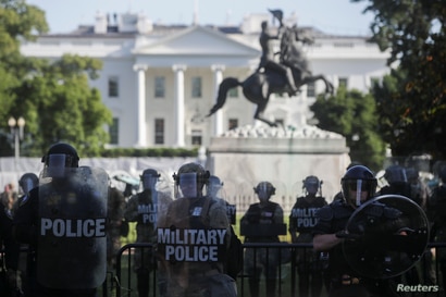 DC National Guard military police officers look on as demonstrators rally near the White House against the death in Minneapolis…